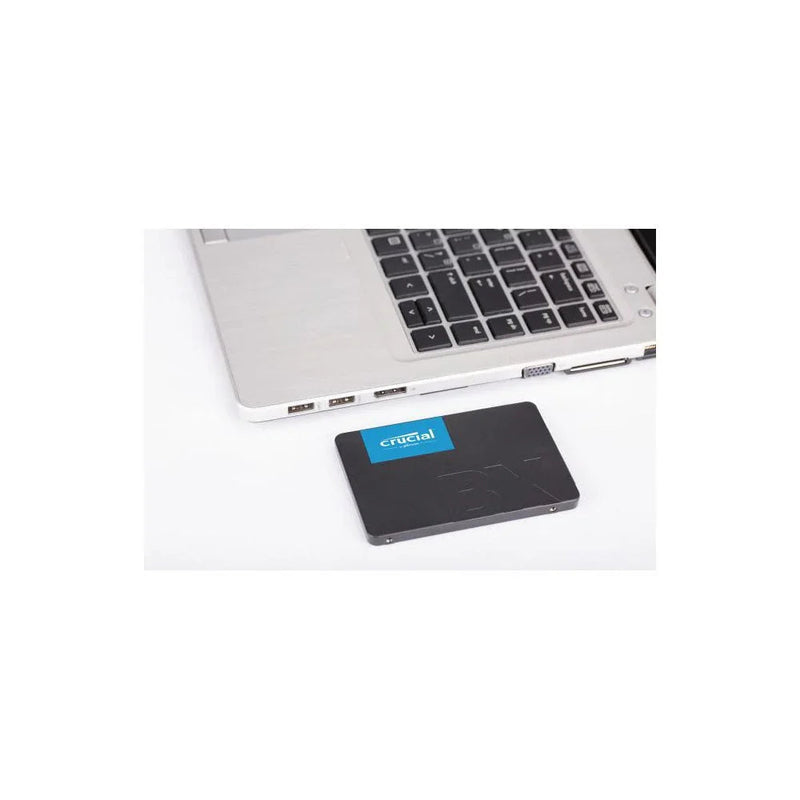 2.5-inch SATA internal SSD placed next to a laptop, suitable for computer storage upgrades