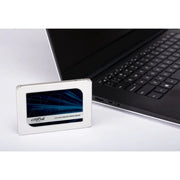 2.5-inch SATA internal SSD placed next to a laptop on a white surface