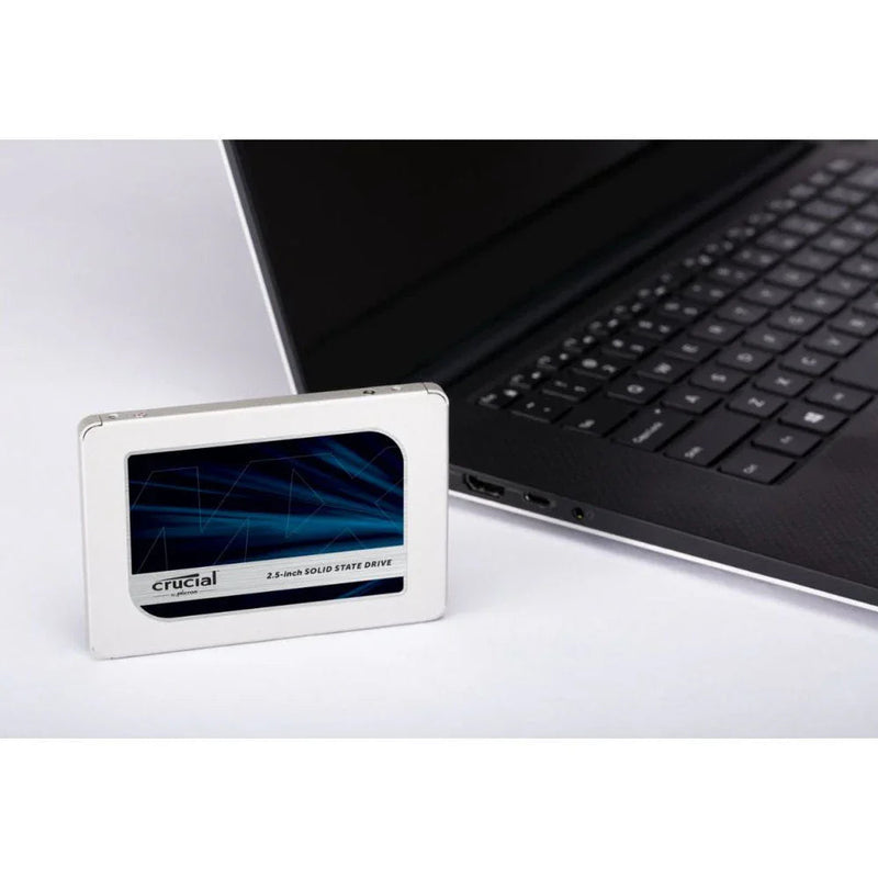 2.5-inch SATA internal SSD placed next to a laptop on a white surface