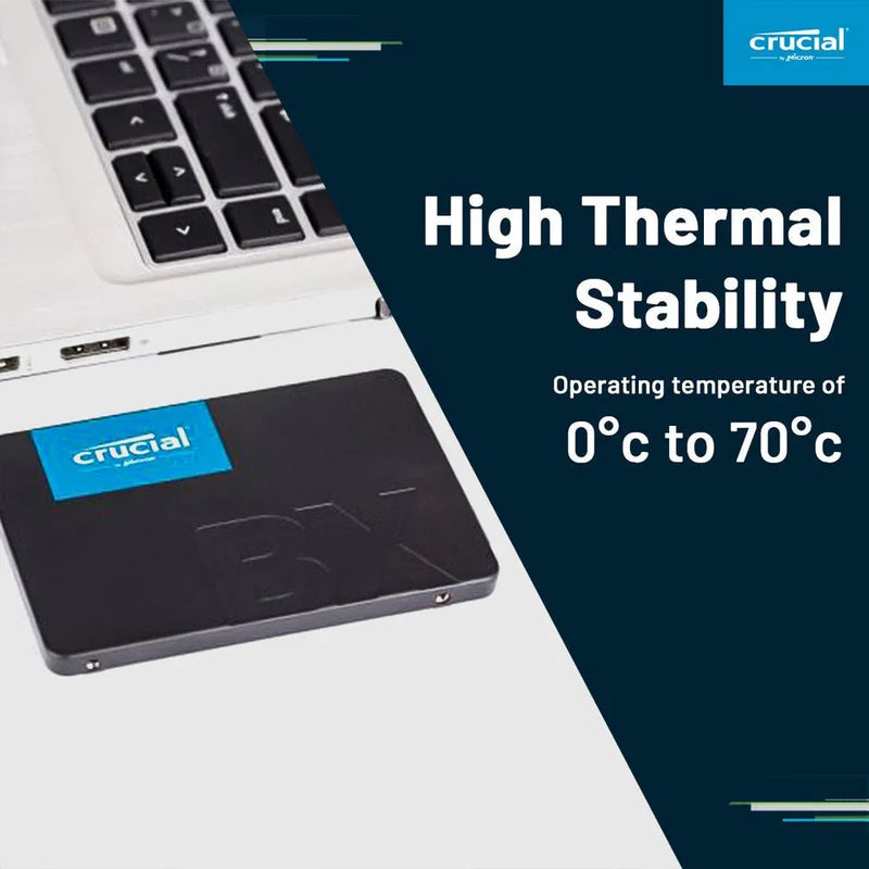 Crucial BX500 500GB internal SSD near laptop, high thermal stability, SATA 2.5 inch drive